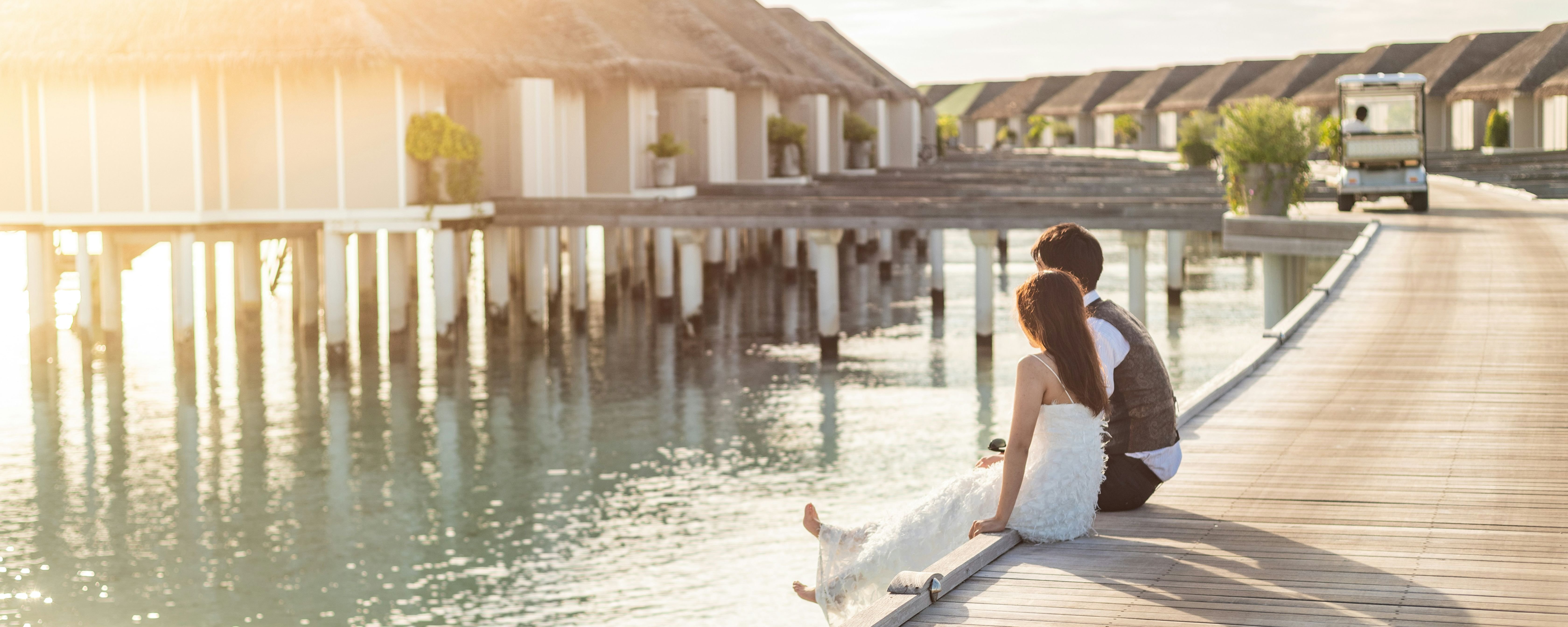 Couple enjoys a romantic Maldives tour sunset, relaxing by overwater villas.