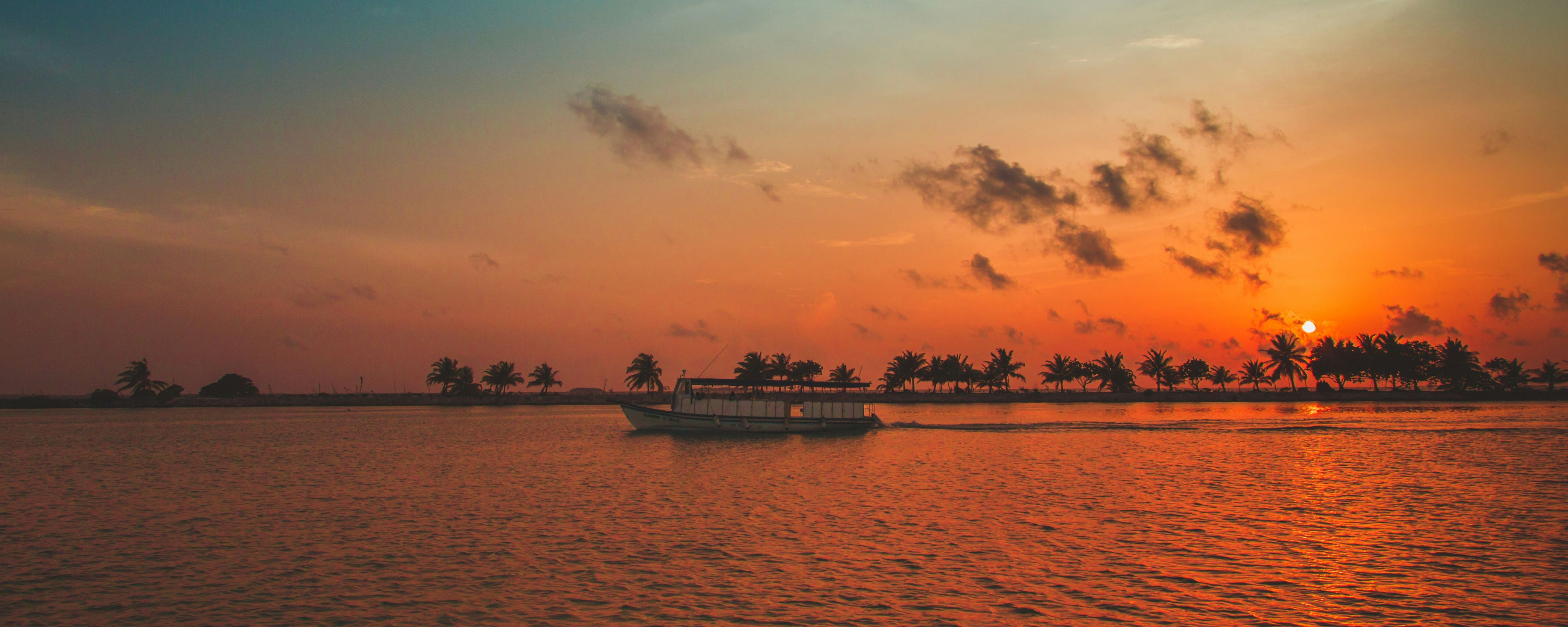 Maldives tour sunset cruise with boat on the water.