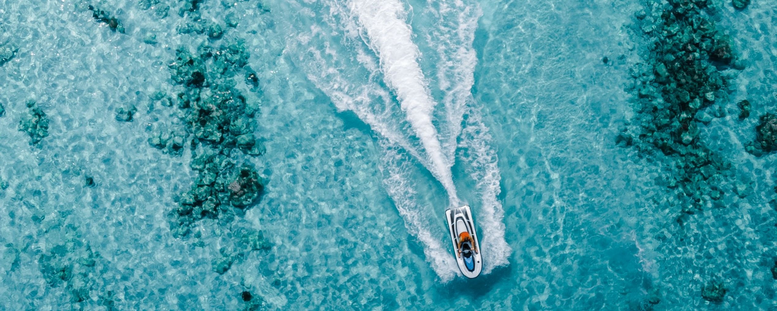 person on jet ski Maldives tour, clear water.
