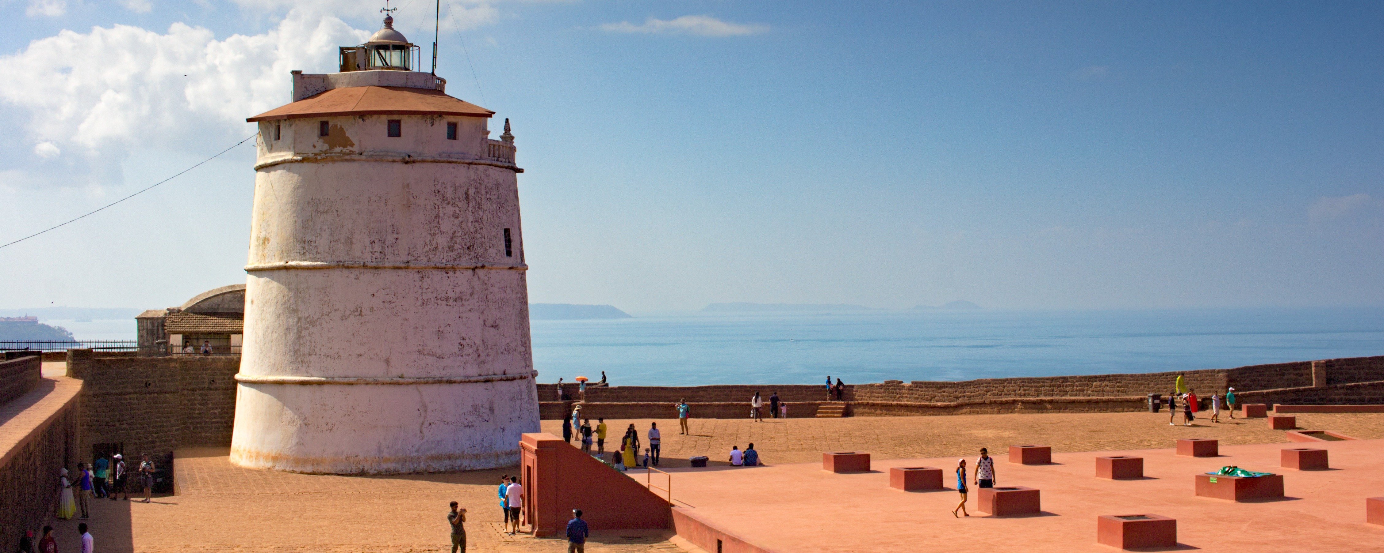 Fort Aguada Goa tour, historic Portuguese fort with lighthouse overlooking sea.