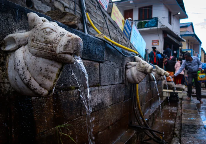 Stone water spouts, or "naulas," flowing with fresh water in the Himalayas during the Char Dham Yatra.