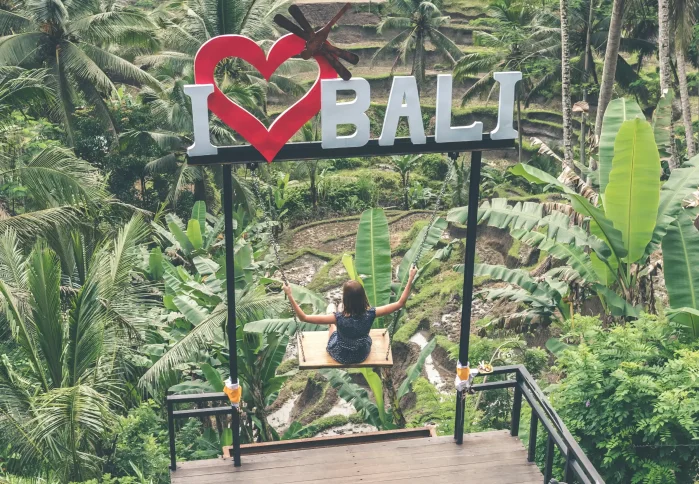 Bali tour excitement: a girl swinging over rice paddies. It looks like a fun trip.