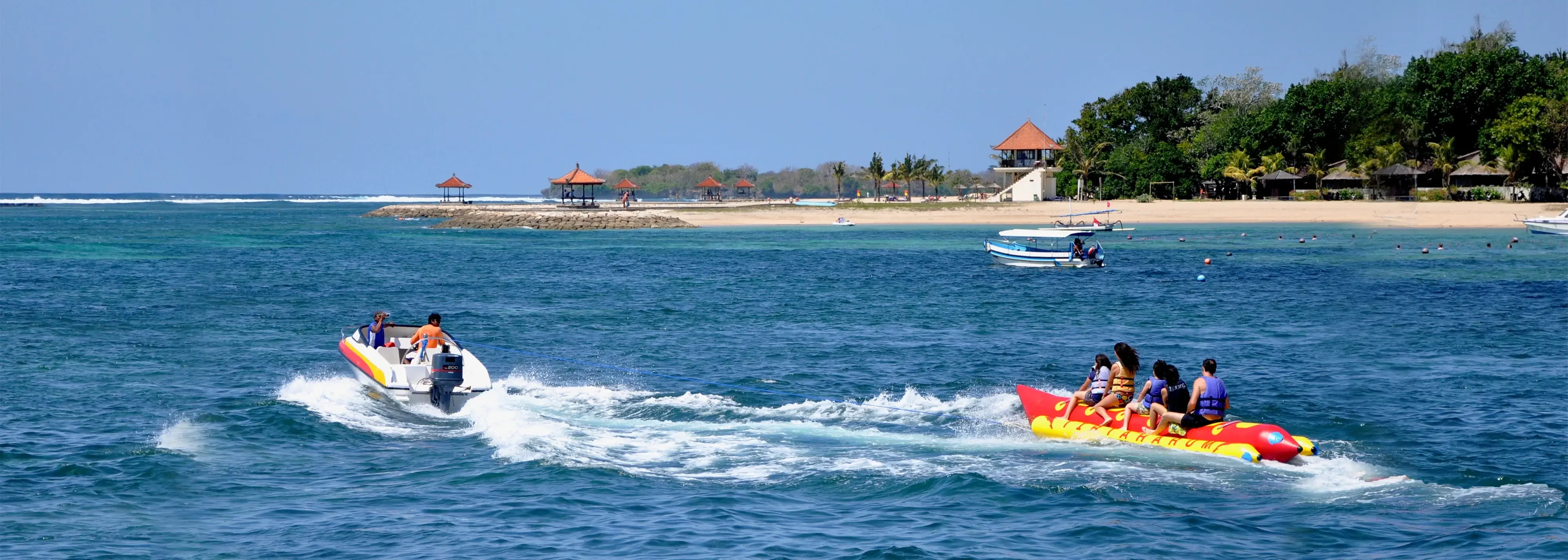 Exciting banana boat activity on a clear blue sea, perfect for a memorable Bali tour.