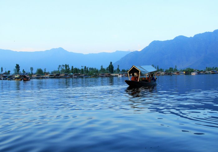 Dal Lake, Kashmir tour scene. Shikara boat on calm water. Good for people planning Kashmir tour.