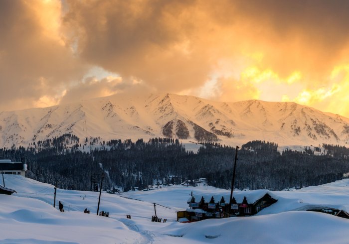 Snowy Gulmarg mountains, pines. Perfect Kashmir tour spot for winter fun.